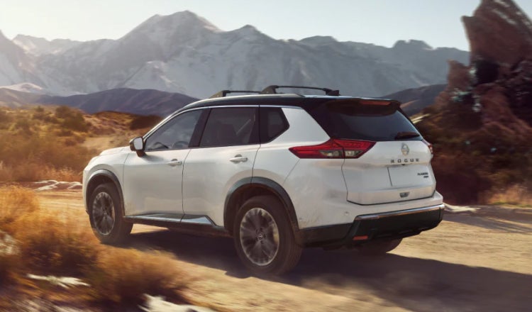 White Nissan SUV driving on desert road